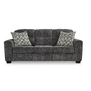 A dark gray three-seater sofa with textured upholstery, accompanied by two patterned accent pillows.