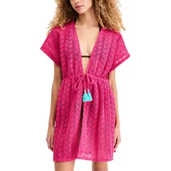 A woman wears a hot pink, open-knit beach cover-up with short sleeves and a drawstring waist featuring blue tassels.