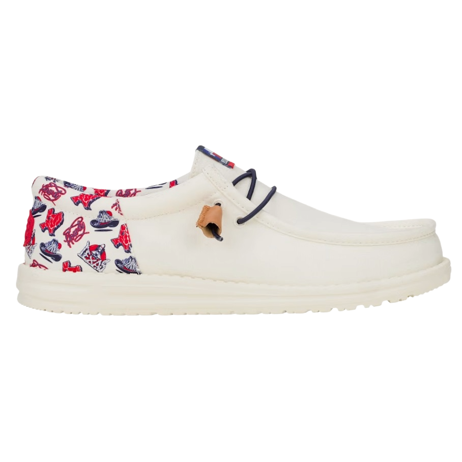 Cream-colored slip-on shoe with a unique red and blue graphic pattern on the heel and collar, featuring dark lace accents and a tan leather detail.