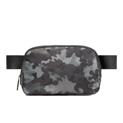 A camouflage-patterned belt bag with a zippered main compartment, featuring a black adjustable strap and subtle branding on the front.