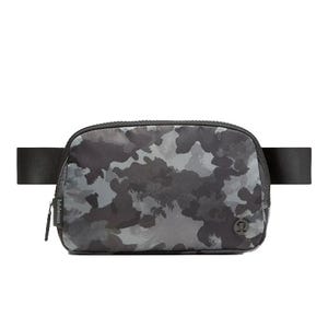 A camouflage-patterned belt bag with a zippered main compartment, featuring a black adjustable strap and subtle branding on the front.