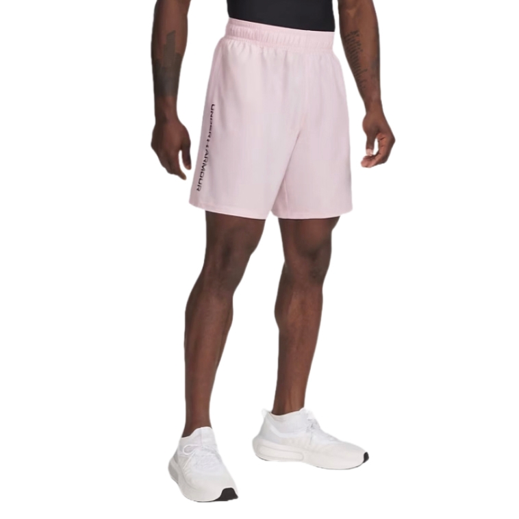 A person is wearing light pink Under Armour shorts with a black logo on the side, paired with white athletic shoes and a black top.