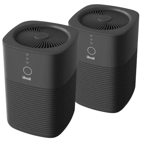 Two Levoit air purifiers with a sleek, black design, featuring circular control panels on the front and vent openings on the top.
