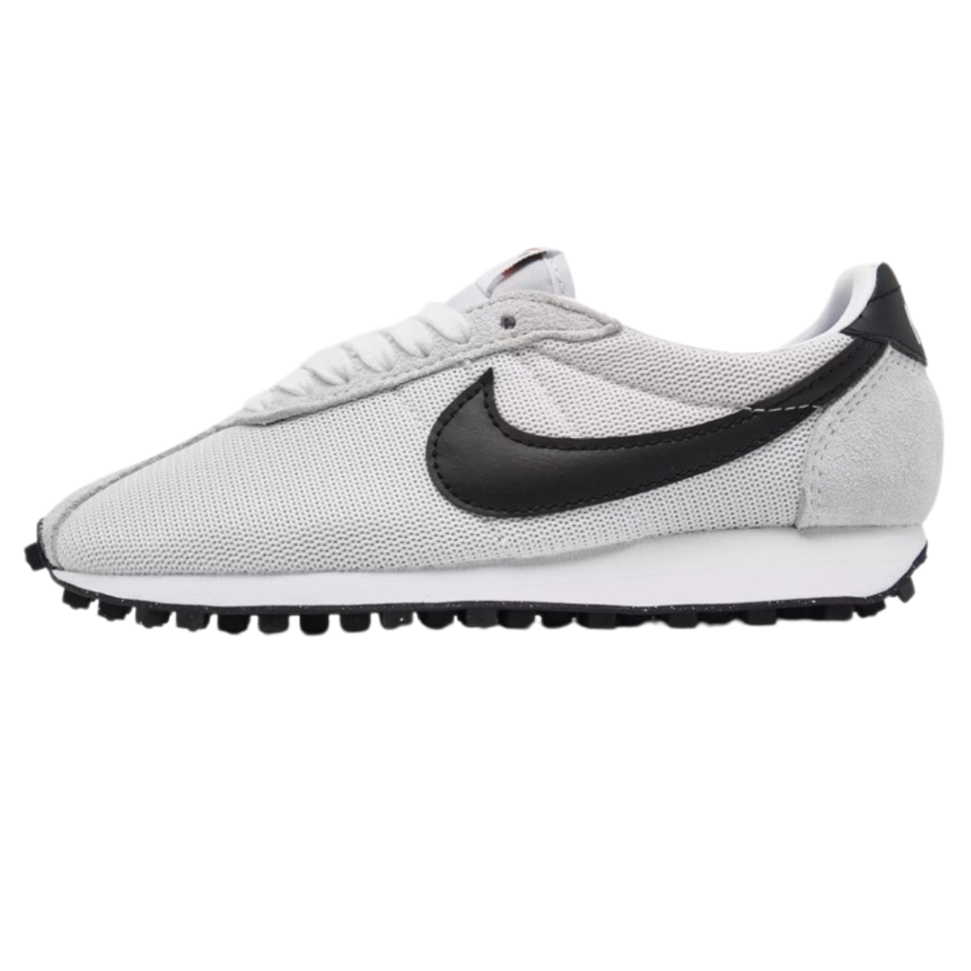 White and black Nike sneaker with a mesh upper, suede accent on heel, and a textured rubber sole.