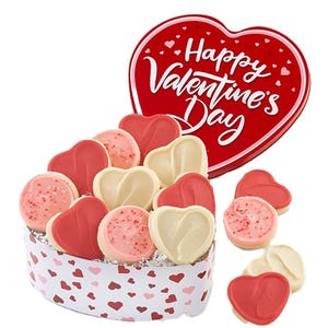 A heart-shaped tin labeled \“Happy Valentine's Day\“ contains assorted heart-shaped cookies in pink, white, and red with sprinkles. The tin features a pattern of hearts.