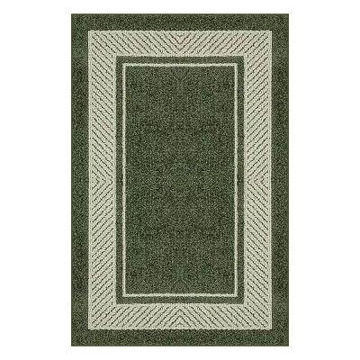 A green rectangular throw rug with a lighter border and a diamond-patterned edge.