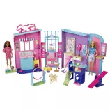 A playset featuring a pet care center with various accessories, including two dolls, a grooming area, agility toys for pets, and a small dog figure, all set in a colorful pink and blue environment.