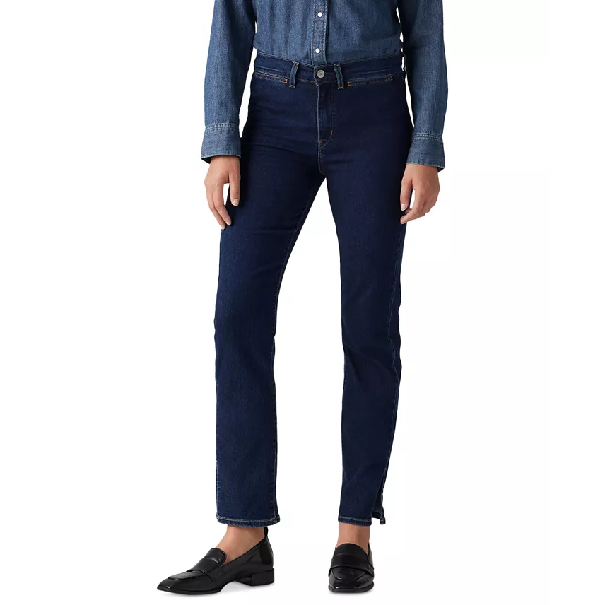 A person is wearing dark blue straight-leg jeans paired with a matching denim shirt and black loafers.