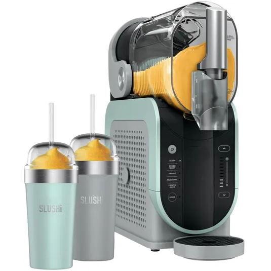 A slushie machine with a transparent container dispensing orange slush, accompanied by two insulated cups with straws labeled \“SLUSHi.\“