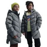 Two children wearing gray Nike puffer jackets. The child on the left has a yellow beanie and the one on the right wears a shirt with a Nike logo.