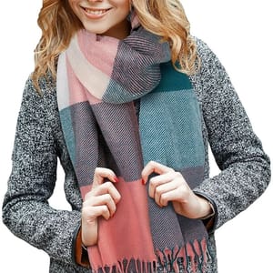A person is wearing a multicolored, checkered scarf with fringe ends over a textured grey coat.