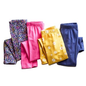 Four pairs of Jumping Beans leggings in a variety of colors and patterns: navy with floral print, solid pink, yellow with white daisies, and solid navy.