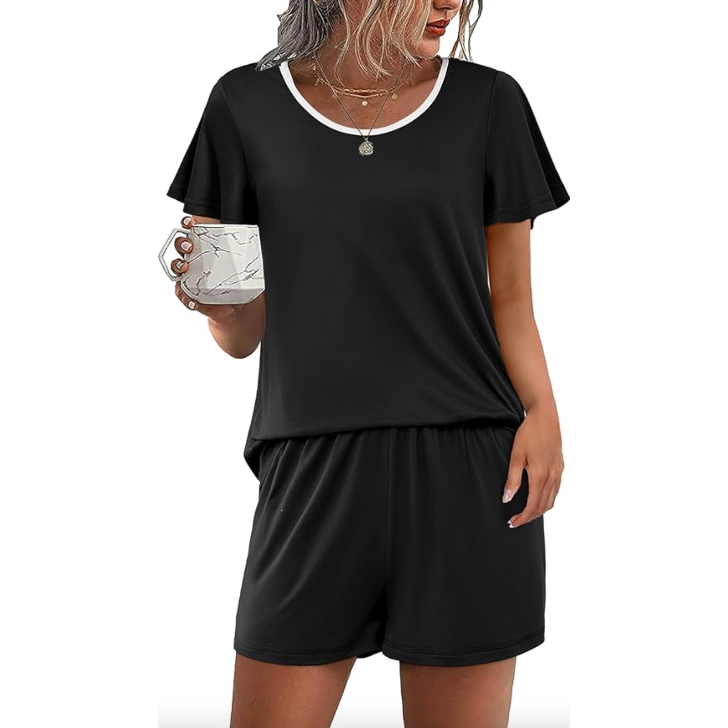 Black short-sleeve top with a white-trimmed neckline and matching shorts. The set is comfortable and casual, paired with a marble-patterned mug.