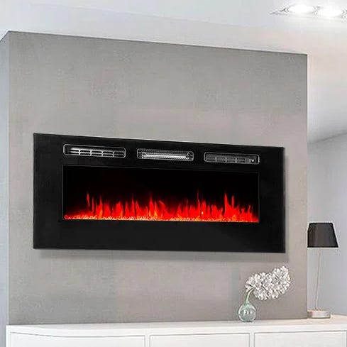 Wall-mounted electric fireplace with a sleek black frame, featuring realistic LED flame effects above a white shelf and a decorative lamp.