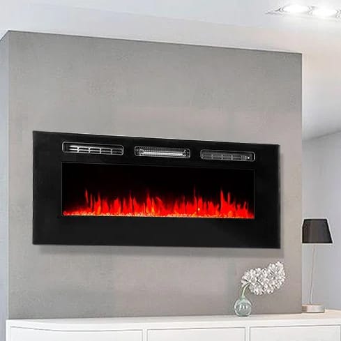 Wall-mounted electric fireplace with a sleek black frame, featuring realistic LED flame effects above a white shelf and a decorative lamp.
