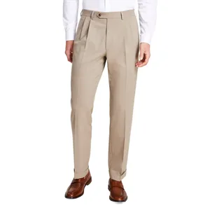 A pair of beige pleated dress pants paired with a white shirt and brown leather loafers.