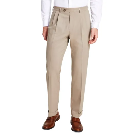 A pair of beige pleated dress pants paired with a white shirt and brown leather loafers.