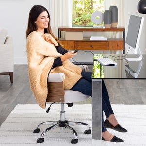 Two USB-powered heating blankets in beige, one worn by a seated woman, offering warmth and comfort with an easily accessible control unit.