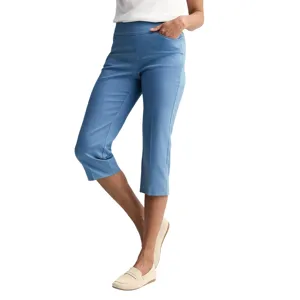A person is wearing blue cropped pants paired with beige loafers and a white top.