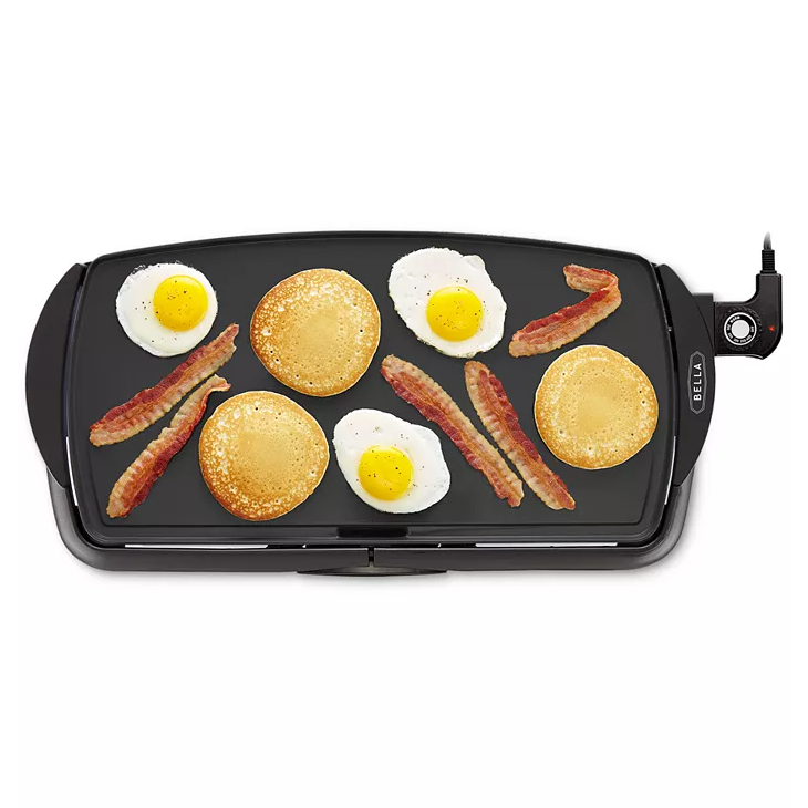 A nonstick electric griddle features a large cooking surface with adjustable temperature control, cooking eggs, pancakes, and bacon. It has a sleek black design with handles on each side for ease of use.