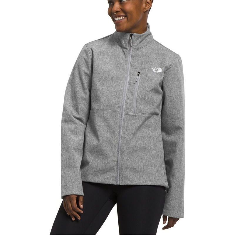 A person wearing a gray The North Face jacket made of soft fabric with a high collar and zippered chest pocket, paired with black leggings.
