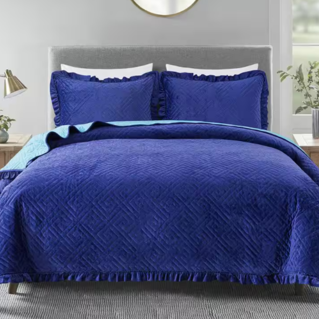 A royal blue Queen-sized velvet quilt set featuring a quilt and two matching pillow shams with a textured geometric pattern and fringed edges.