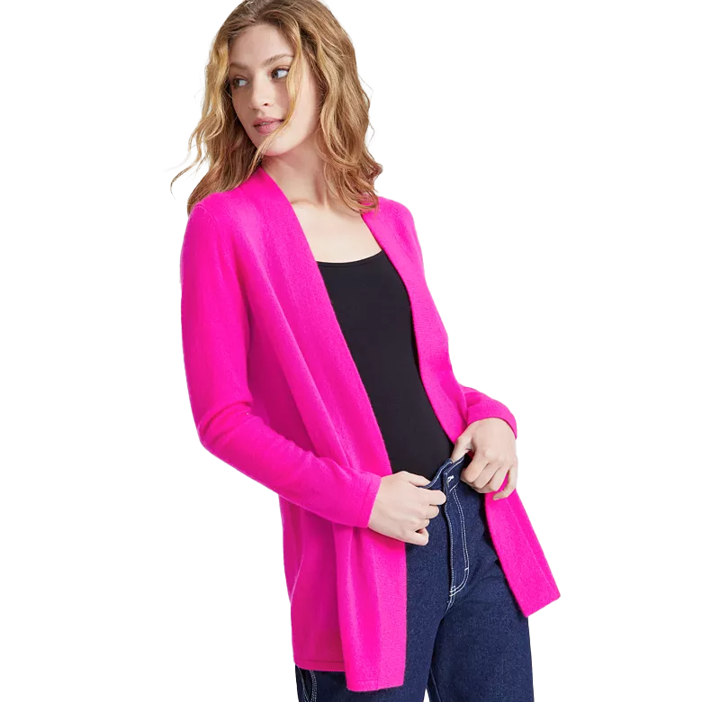 A woman is wearing a bright pink open-front cardigan over a black top and blue jeans.