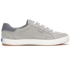 A gray Keds sneaker with a textured pattern, featuring white laces and a white sole with a gum-colored bottom.