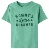 Green children's T-shirt with the text \“Mommy's Little Charmer\“ and clover designs.