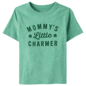 Green children's T-shirt with the text \“Mommy's Little Charmer\“ and clover designs.