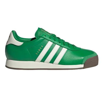A green Adidas Samoa sneaker featuring white stripes and a brown toe cap with \“SAMOA\“ text in gold on the side.