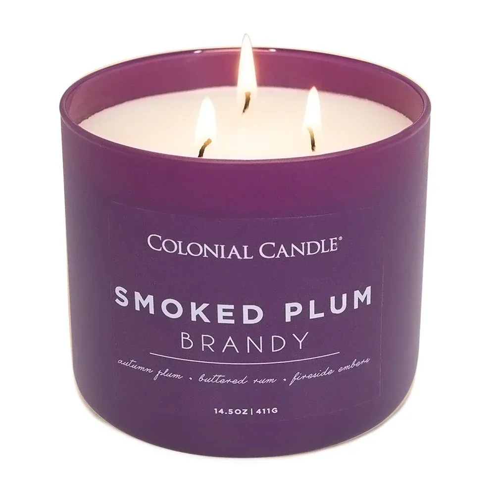 Colonial Candle Smoked Plum Brandy features scents of autumn plum, buttered rum, and fireside embers. It's a 14.5 oz, three-wick candle.