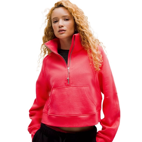 A person is wearing a bright pink quarter-zip pullover with a front pocket, paired with black pants.