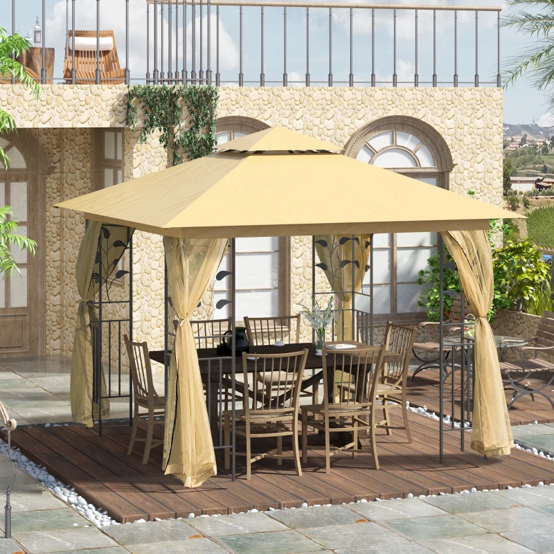A beige gazebo with decorative patterns, featuring a metal frame and sheer curtains, covers an outdoor dining set with a table and chairs on a wooden deck surrounded by pebbles.