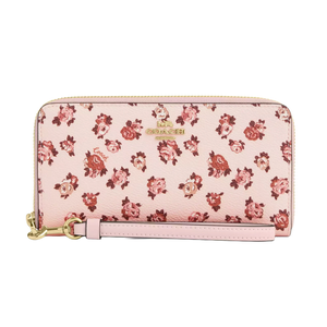 A pink Coach Outlet zip-around wallet with an all-over floral print in shades of pink and red, featuring a gold logo and a detachable wrist strap.