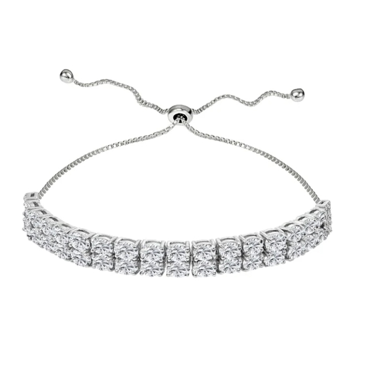 A silver bracelet featuring two rows of round clear stones is adjustable with a sliding mechanism and two dangling chains for a customizable fit.