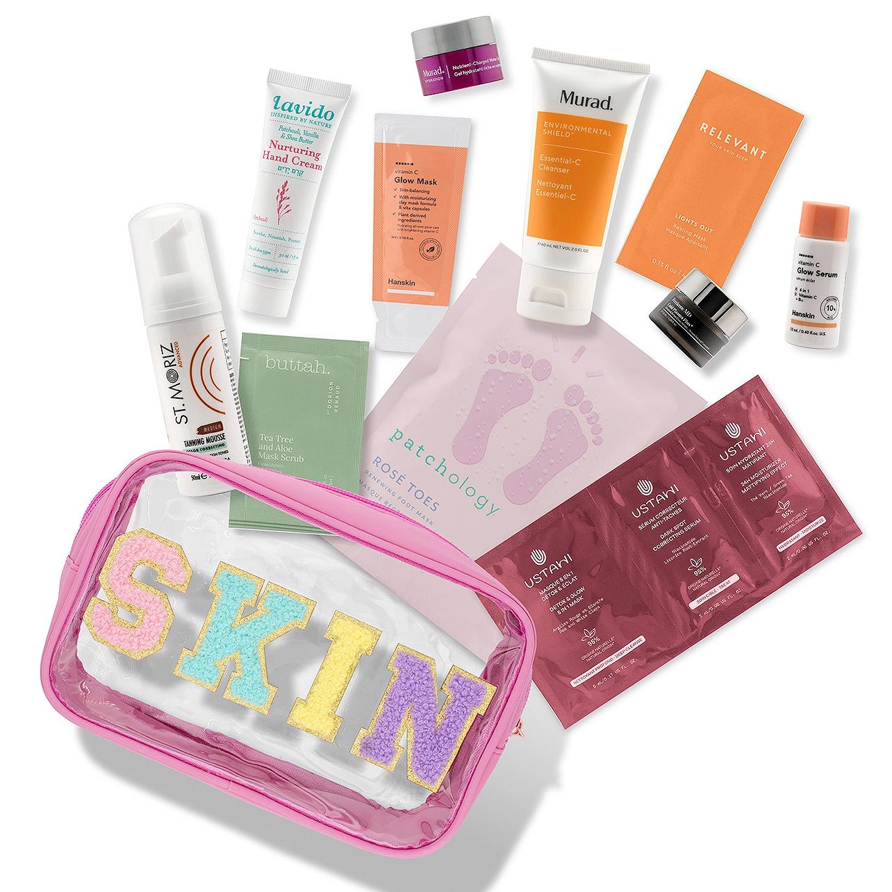 12-piece skin care set includes Lavido hand cream, Hanskin glow mask, Murad cleanser, Relevant skin light, Patchology foot mask, St. Moriz tanning mousse, Buttah scrub, Murad night cream, Hanskin glow serum, and Ustawi firming packets, all in a pink \“SKIN\“ bag.