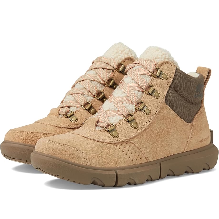 A pair of beige ankle-length boots with plush lining and lace-up fronts.