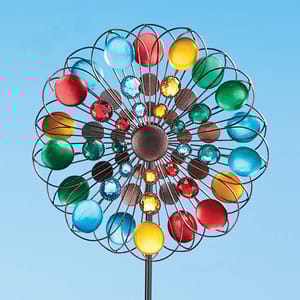A colorful outdoor wind spinner with reflective multicolored disks and crystal-like beads.
