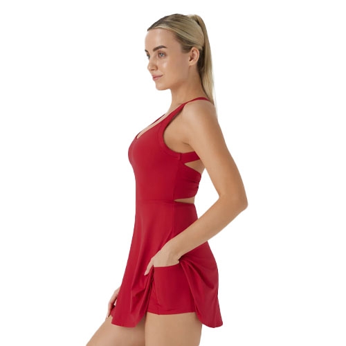 A woman is wearing a red sleeveless dress with a fitted top and a flared skirt. The dress features a backless design with twist details and has practical pockets on the sides.