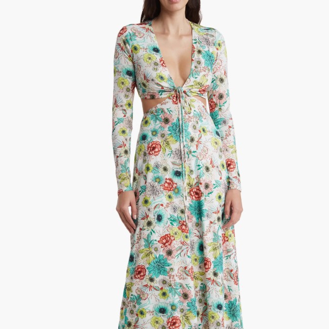 A long-sleeved maxi dress featuring a cutout waist detail and a floral pattern in a mix of vibrant colors on a white background.