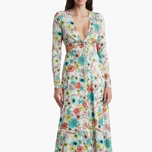 A long-sleeved maxi dress featuring a cutout waist detail and a floral pattern in a mix of vibrant colors on a white background.