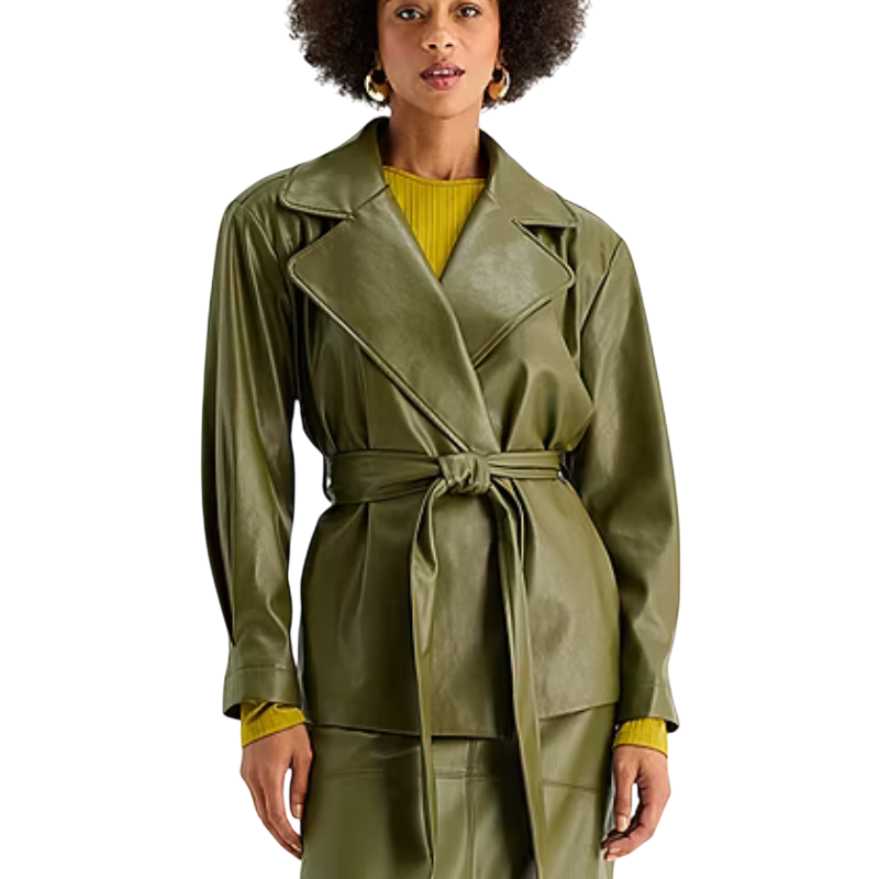 A woman wears an olive green faux leather belted jacket over a yellow sweater.