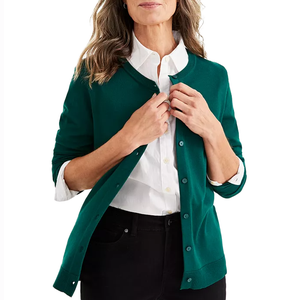 A green button-up cardigan with long sleeves and a ribbed hemline, worn over a white collared shirt.