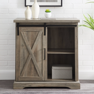 A wooden cabinet with a rustic finish has a sliding barn door and open shelving, decorated with vases and a small potted plant.