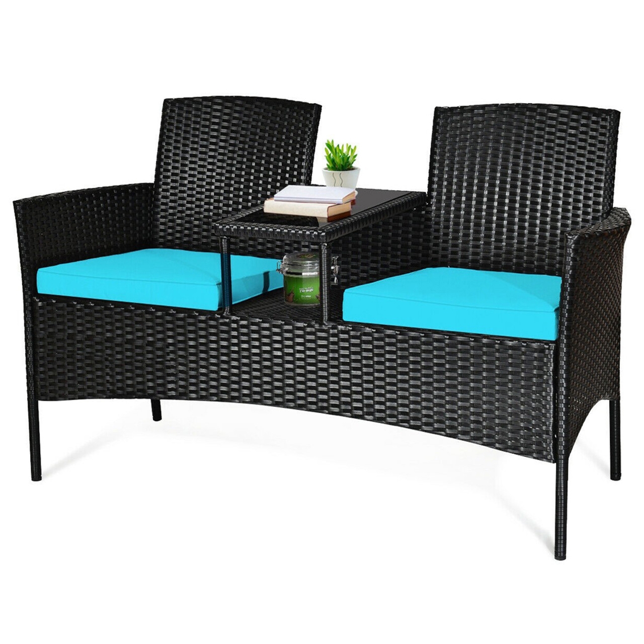 Outdoor loveseat with black wicker frame, turquoise cushions, and a center table. The table has a glass top with a lower shelf, holding a plant, books, and a candle.