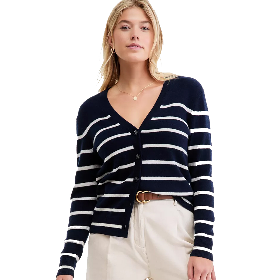 A woman wearing a navy blue and white striped cardigan with a V-neck and button closure, paired with beige pants and a brown belt.