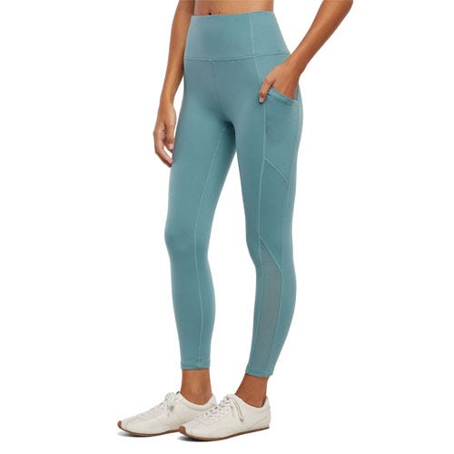 High-waisted blue leggings with side pockets, paired with white sneakers.