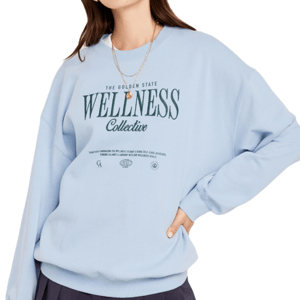 A person is wearing a light blue sweatshirt with \“The Golden State Wellness Collective\“ text and a small graphic logo.