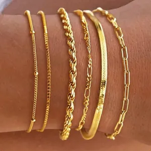 A set of five 14K gold bracelets, each with a unique chain design: two with sleek thin strings, one with a twisted rope style, one flat and textured, and one with elongated links. They are waterproof and designed to be worn stacked.